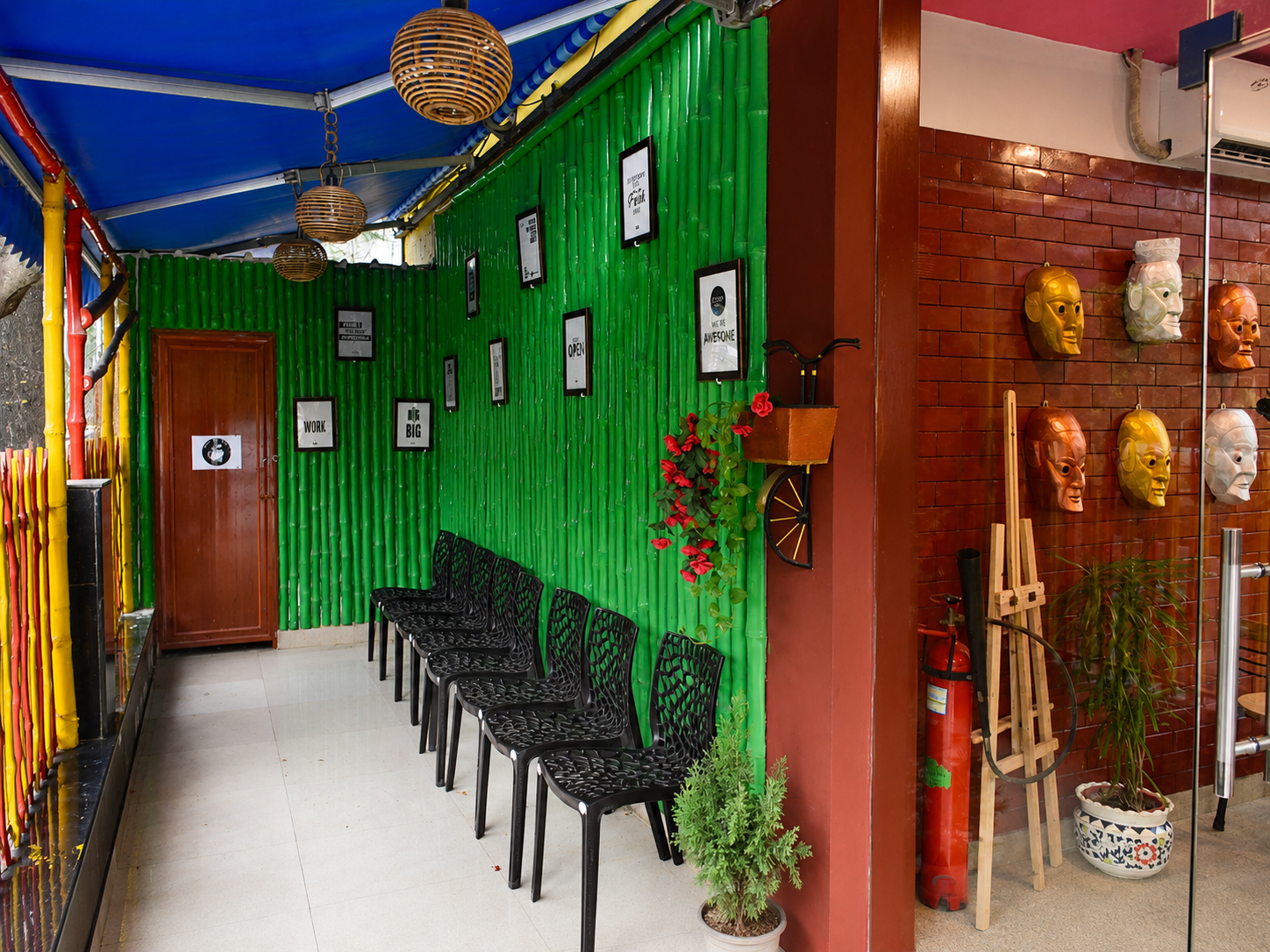 Green bamboo wall waiting area with framed prints and masks