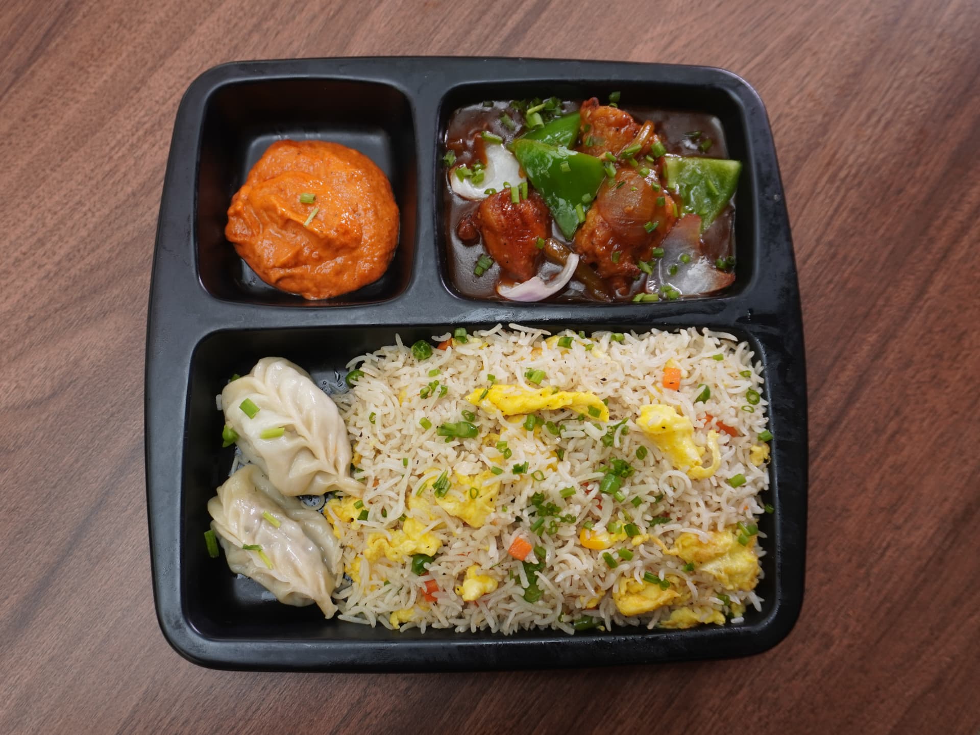 Combo meal tray with momos, egg fried rice and chilli chicken