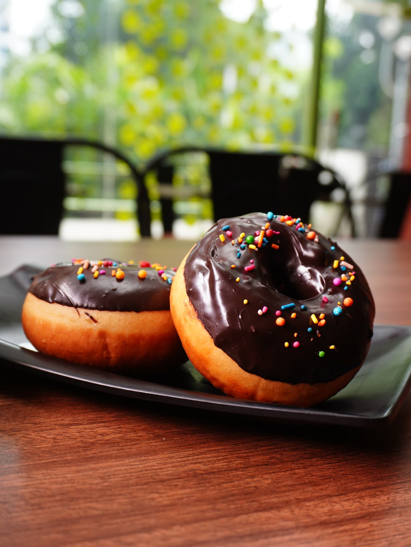 Chocolate glazed doughnuts with rainbow sprinkles
